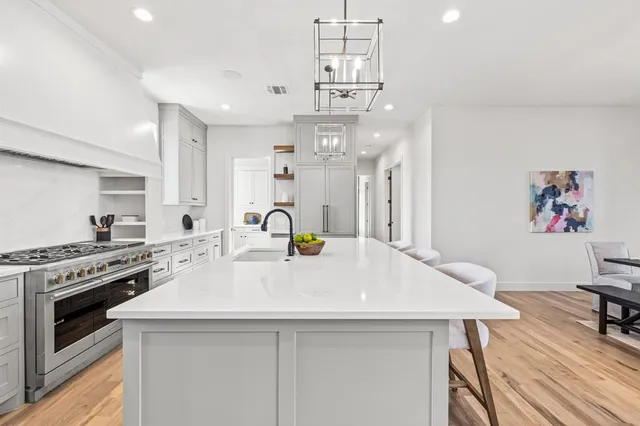 a kitchen with a sink a stove and cabinets
