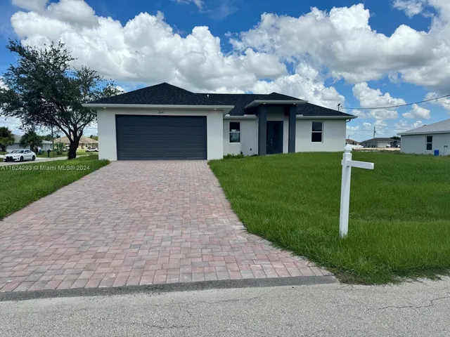 a front view of a house with a yard and garage