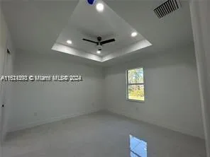 en empty room with windows and ceiling fan
