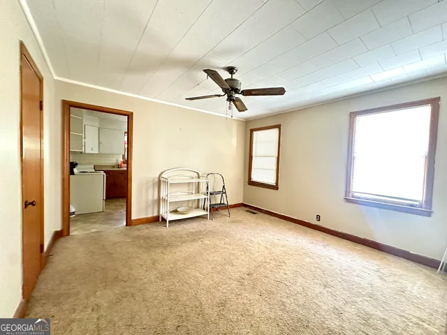 an empty room with windows and a ceiling fan