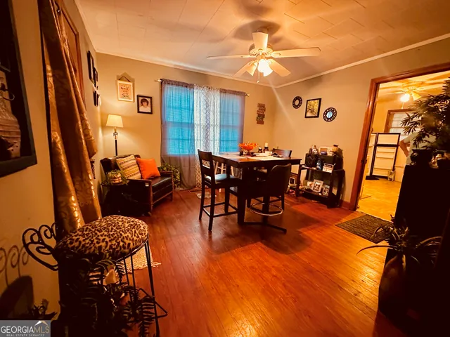 a living room with furniture a dining table and chairs with wooden floor
