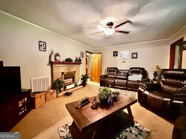 a living room with furniture kitchen view and a flat screen tv