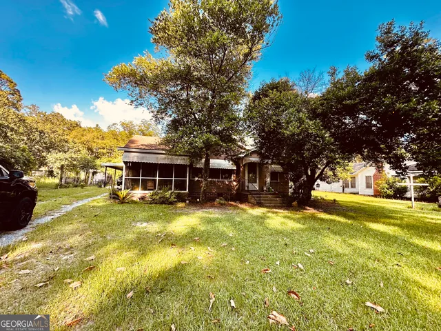 a view of a yard with a house and large trees
