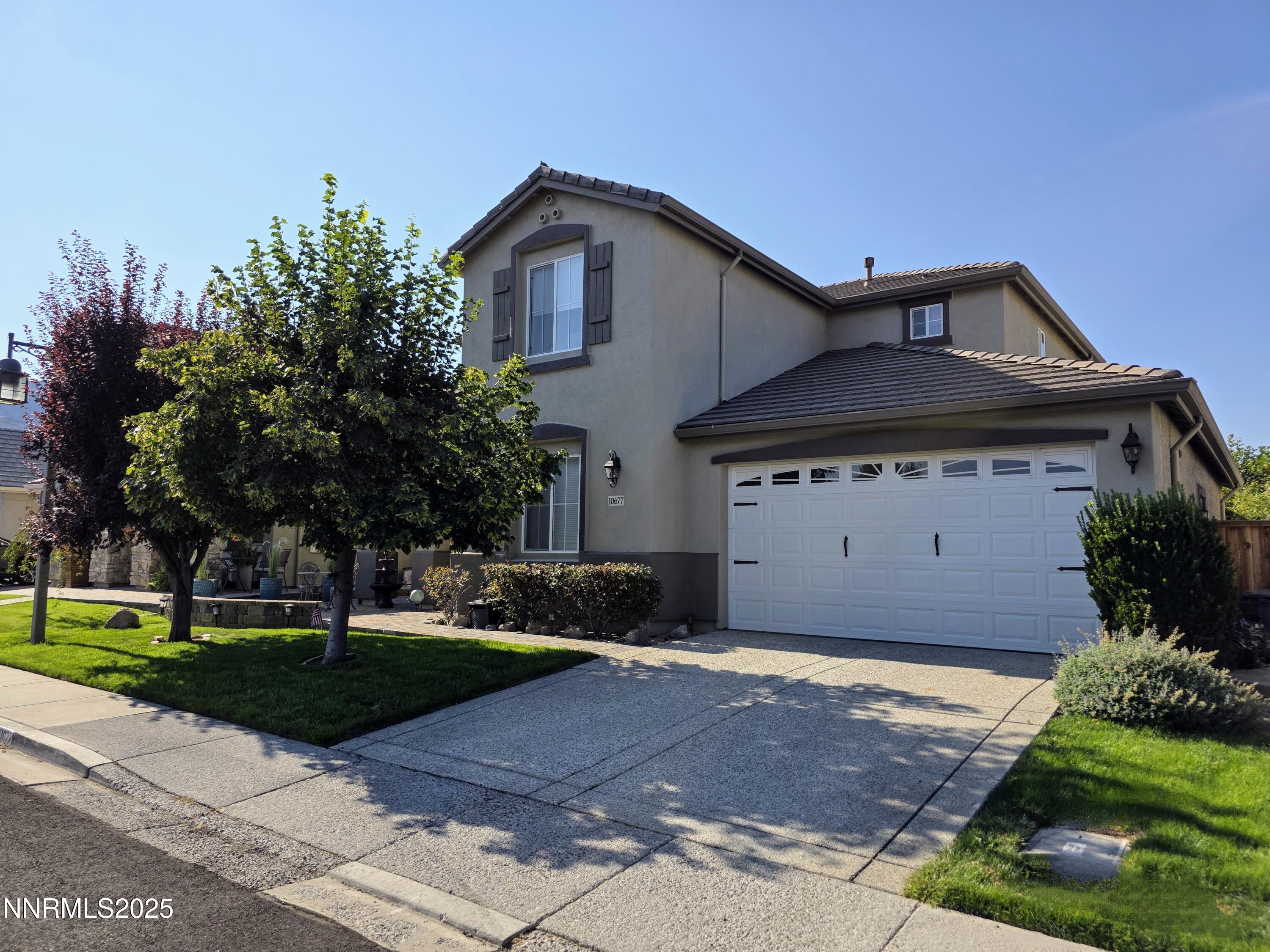 10677 Fire Poppy Circle Reno, NV 89521 - Photo 1 of 45 a front view of a house with a yard and trees