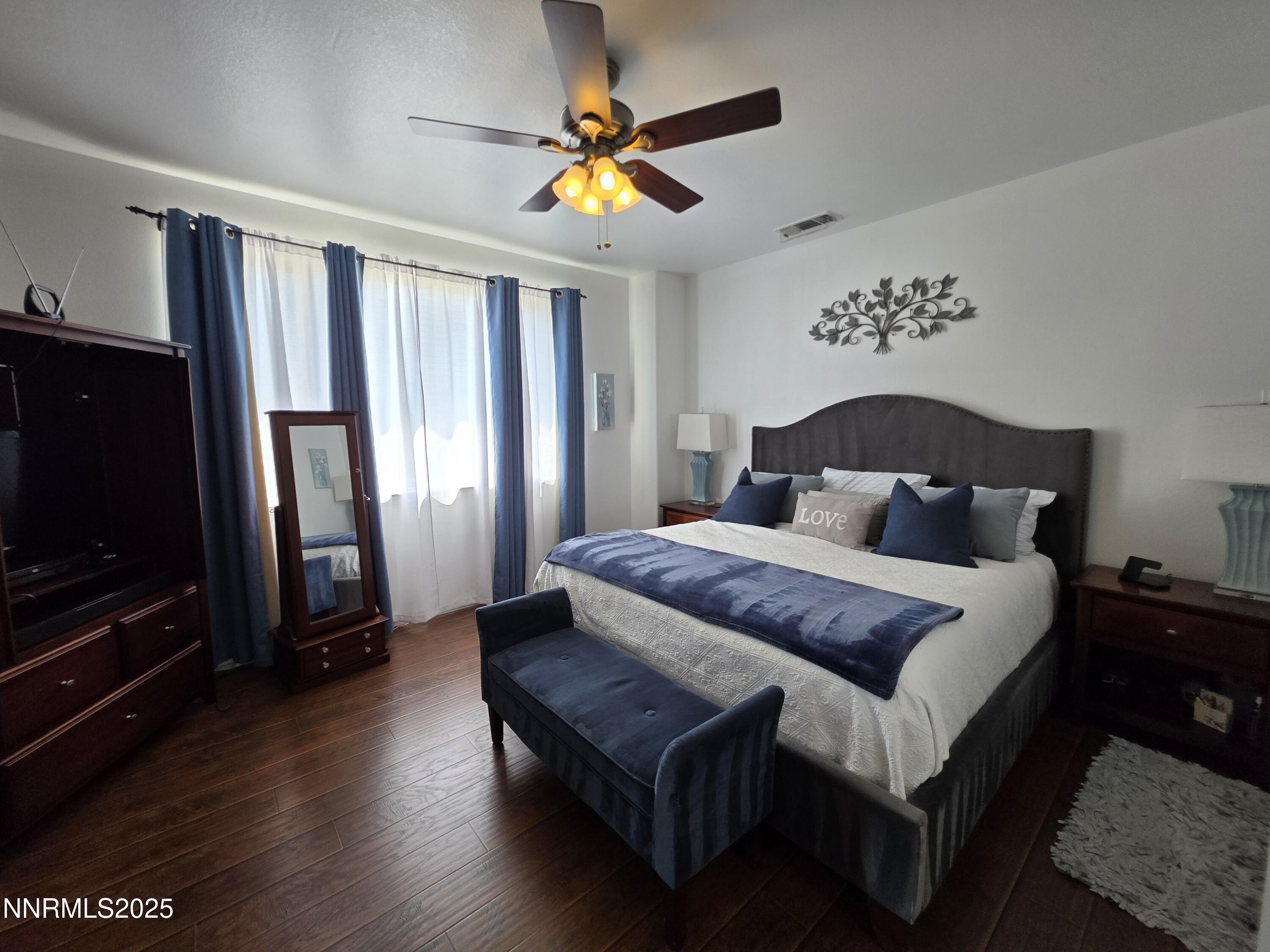 10677 Fire Poppy Circle Reno, NV 89521 - Photo 15 of 45 a bedroom with a bed and a chandelier