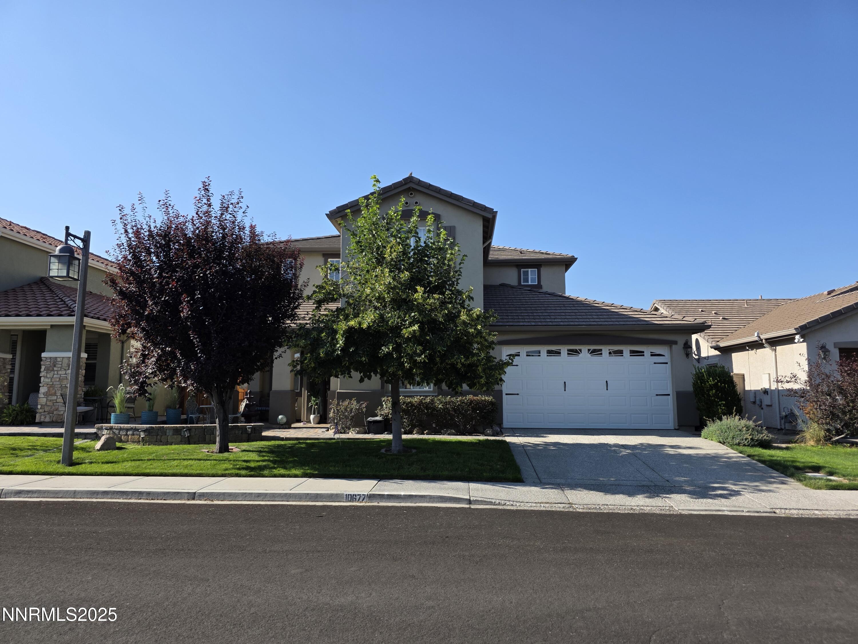 10677 Fire Poppy Circle Reno, NV 89521 - Photo 2 of 45 a front view of a house with a garden and trees