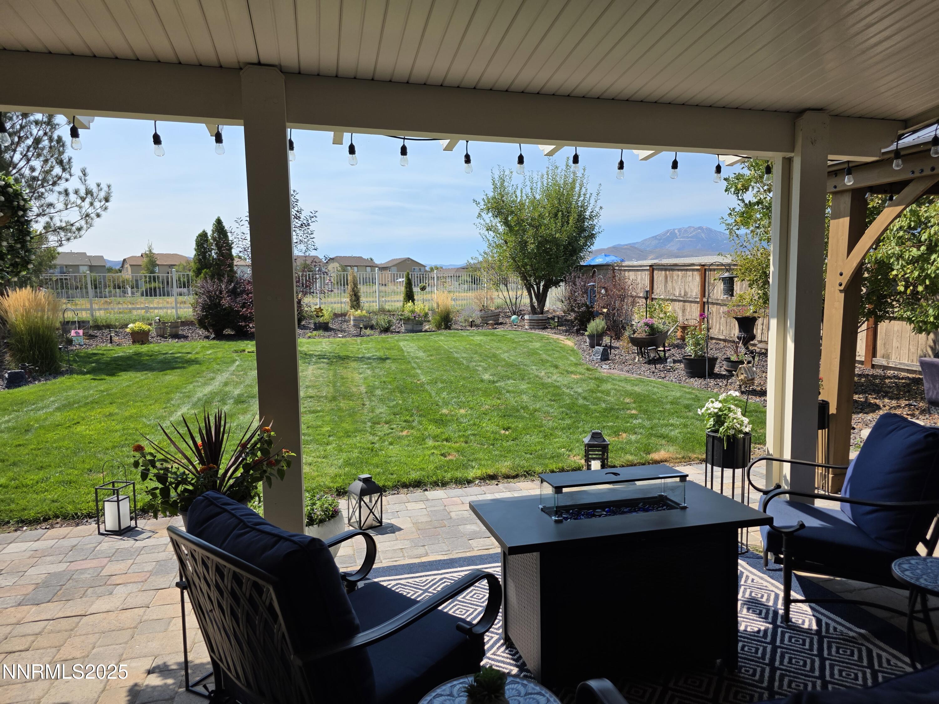 10677 Fire Poppy Circle Reno, NV 89521 - Photo 24 of 45 a view of a patio with table and chairs potted plants with wooden fence