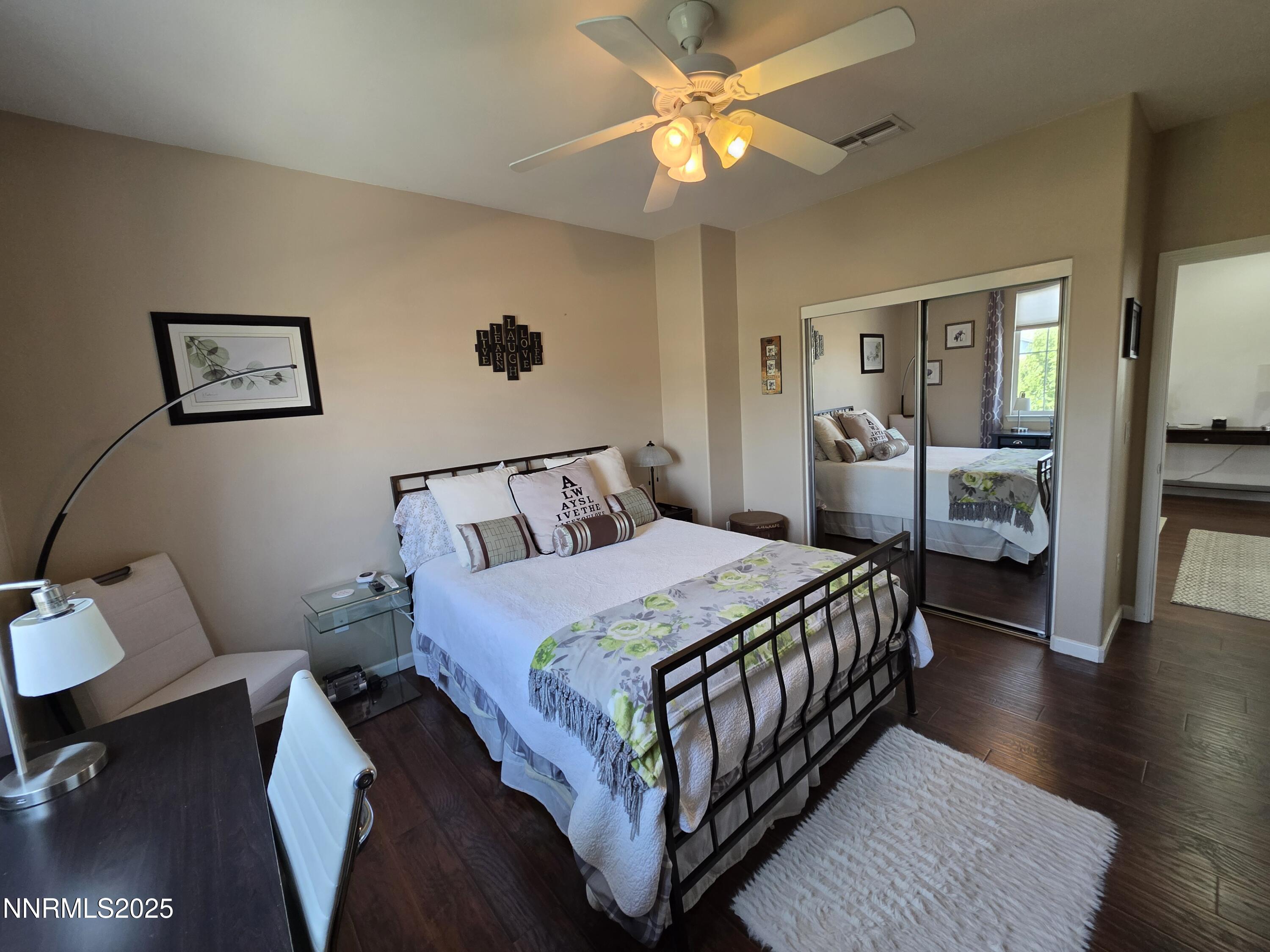 10677 Fire Poppy Circle Reno, NV 89521 - Photo 27 of 45 a bedroom with a bed a chandelier and a dresser