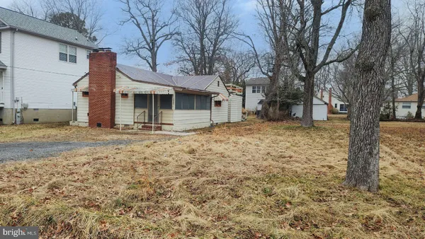 a view of a house with a yard and large tree