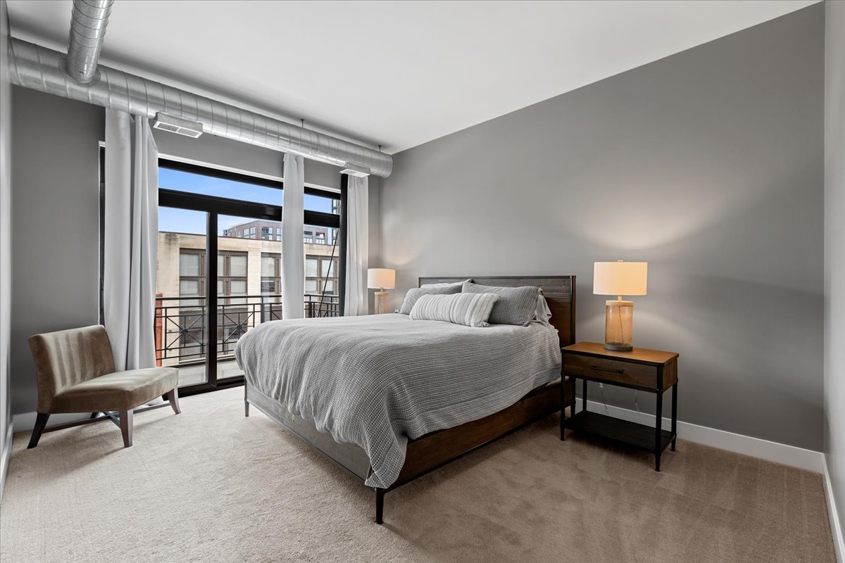 1155 West Madison Street, Unit 603 Chicago, IL 60607 - Photo 12 of 23 a bedroom with a bed and a night stand
