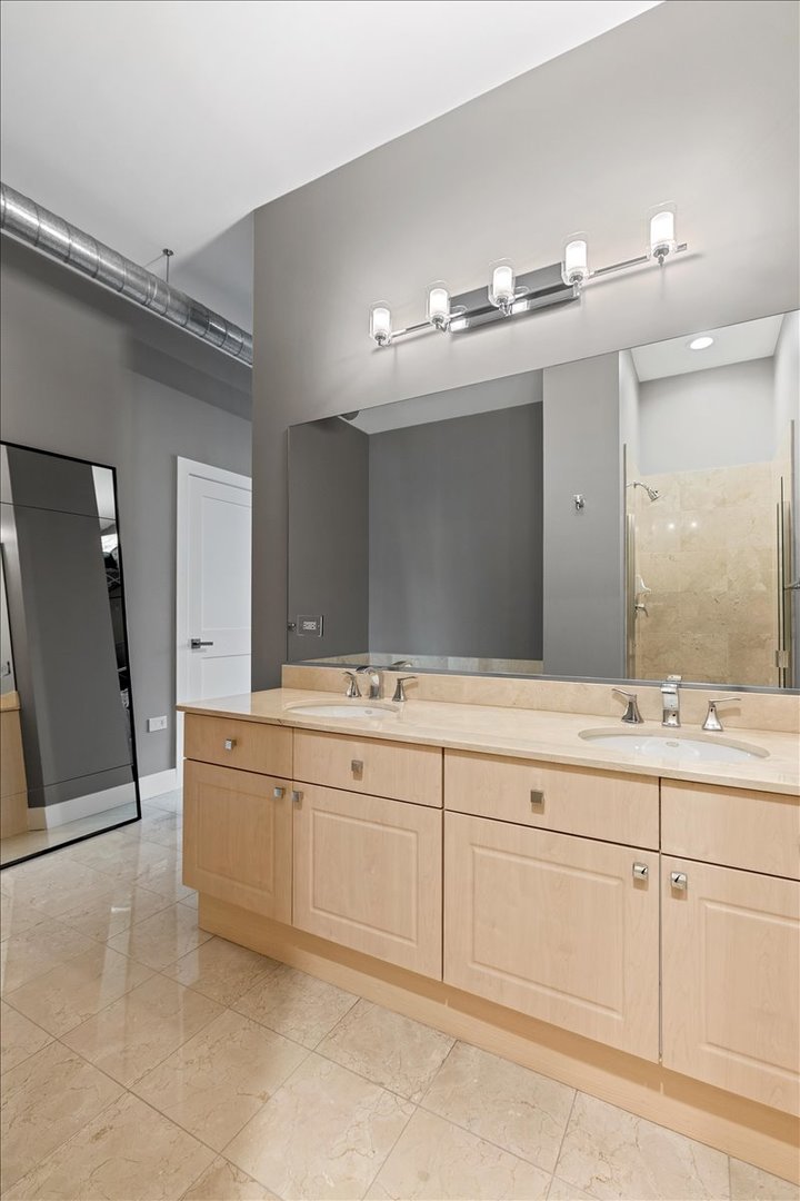 1155 West Madison Street, Unit 603 Chicago, IL 60607 - Photo 16 of 23 a bathroom with a sink vanity and mirror