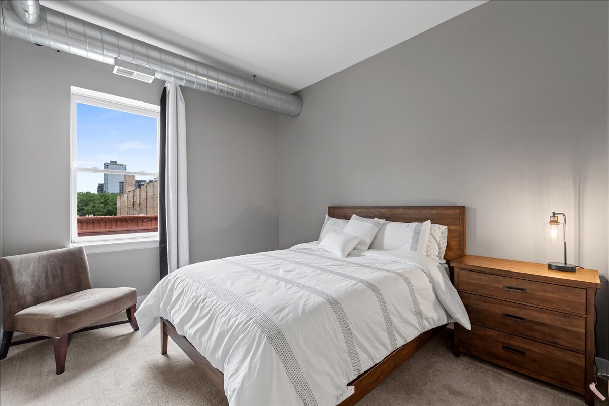 1155 West Madison Street, Unit 603 Chicago, IL 60607 - Photo 17 of 23 a bedroom with a bed and a couch