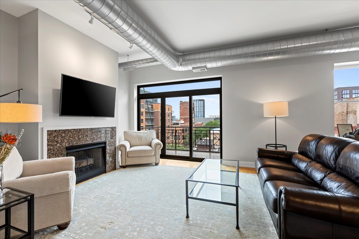 1155 West Madison Street, Unit 603 Chicago, IL 60607 - Photo 4 of 23 a living room with furniture a fireplace and a flat screen tv