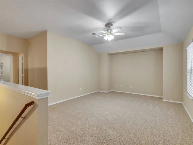 an empty room with windows and fan
