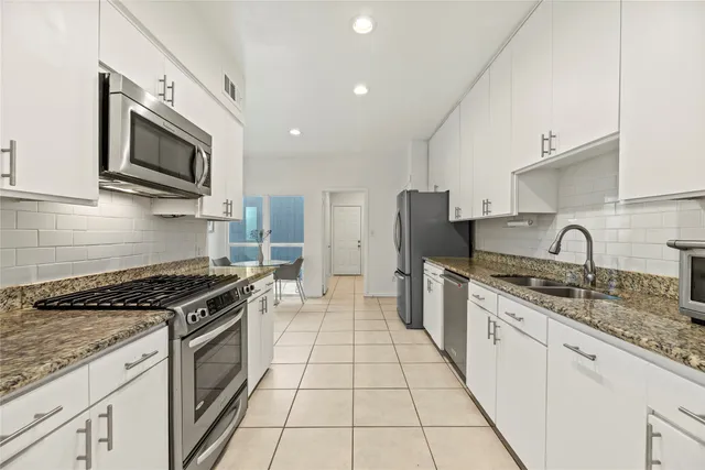 a kitchen with a refrigerator sink and cabinets