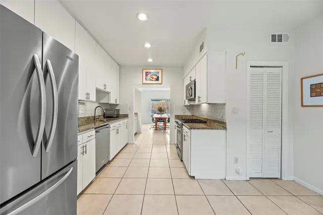 a kitchen with stainless steel appliances granite countertop a refrigerator and a sink