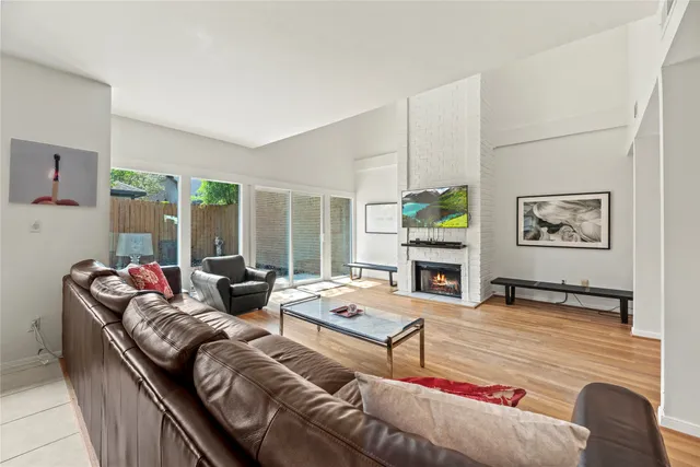 a living room with furniture floor to ceiling window and a fireplace