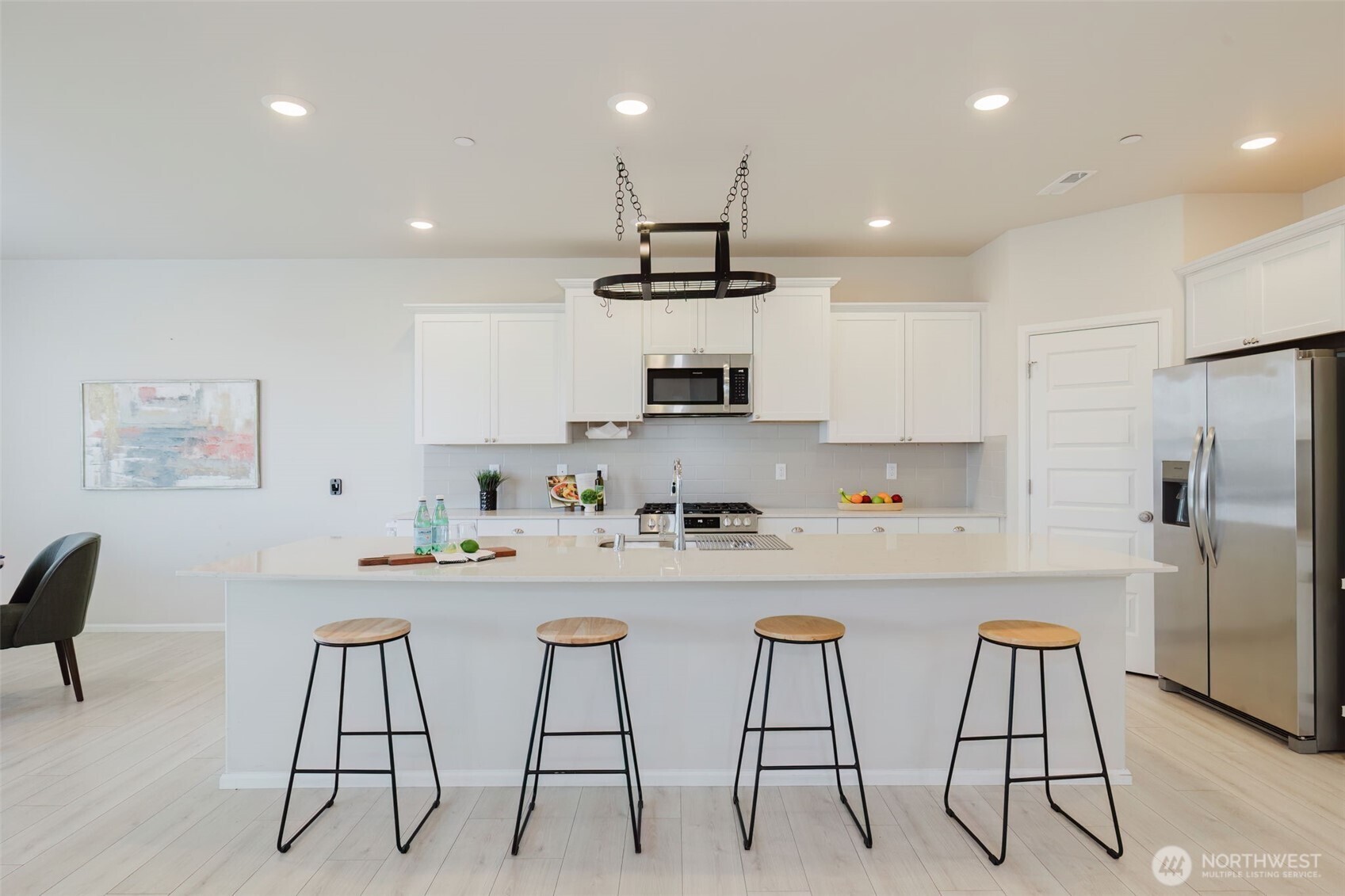 948 Panoramic Loop Bremerton, WA 98312 - Photo 7 of 30 a kitchen with stainless steel appliances kitchen island granite countertop a table chairs refrigerator and microwave