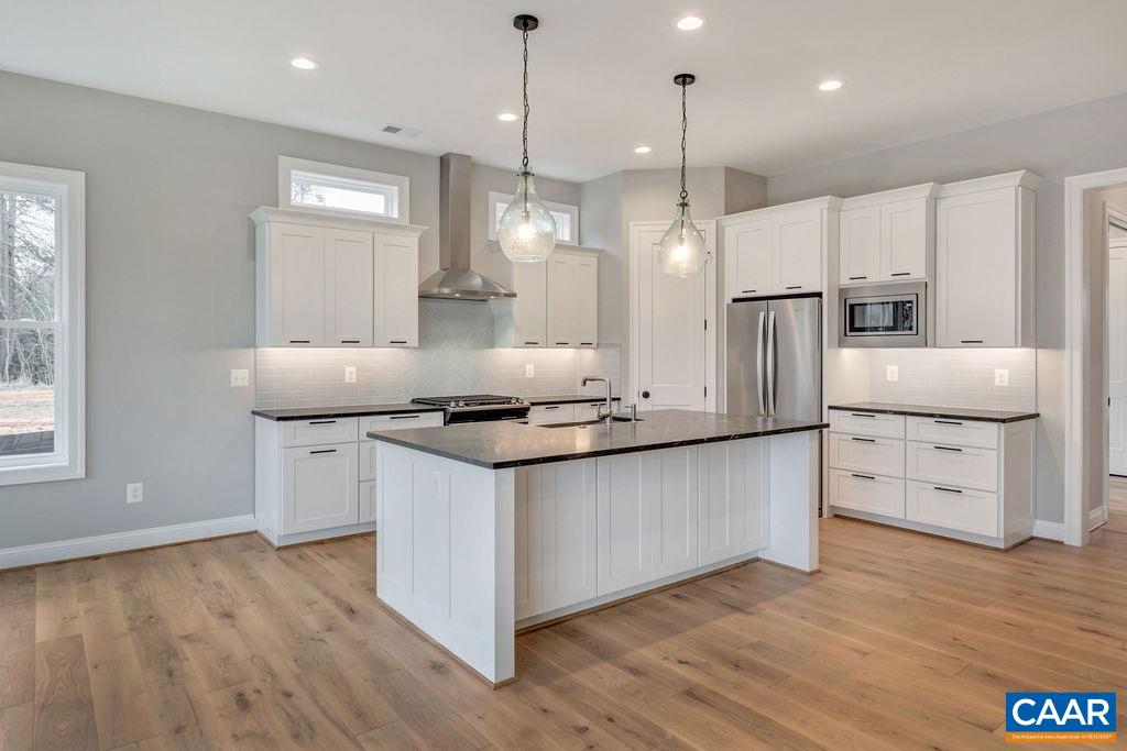 380 Claibourne Road Crozet, VA 22932 - Photo 3 of 25 a kitchen with stainless steel appliances granite countertop a sink a stove a refrigerator and white cabinets with wooden floor
