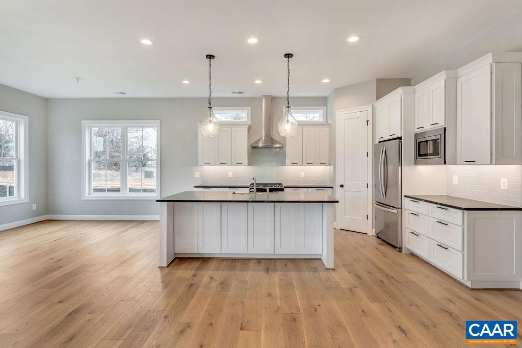 380 Claibourne Road Crozet, VA 22932 - Photo 4 of 25 a kitchen with stainless steel appliances granite countertop a stove a sink a refrigerator and white cabinets with wooden floor