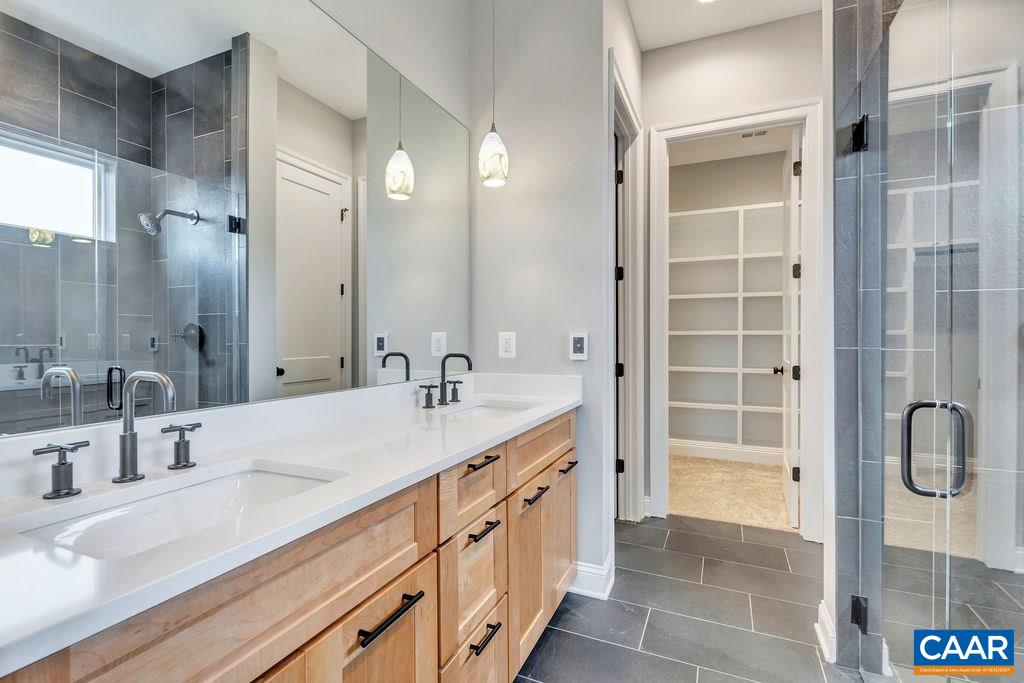 380 Claibourne Road Crozet, VA 22932 - Photo 9 of 25 a bathroom with a double vanity sink a mirror and a shower