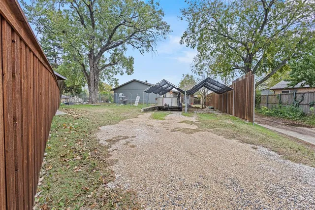 a view of a backyard with table and chairs and wooden fence