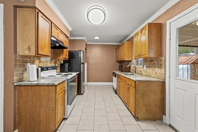 a kitchen with stainless steel appliances granite countertop a refrigerator a stove and a sink