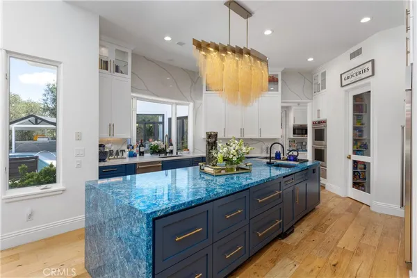 a dining room with wooden floor a chandelier a wooden table and chairs