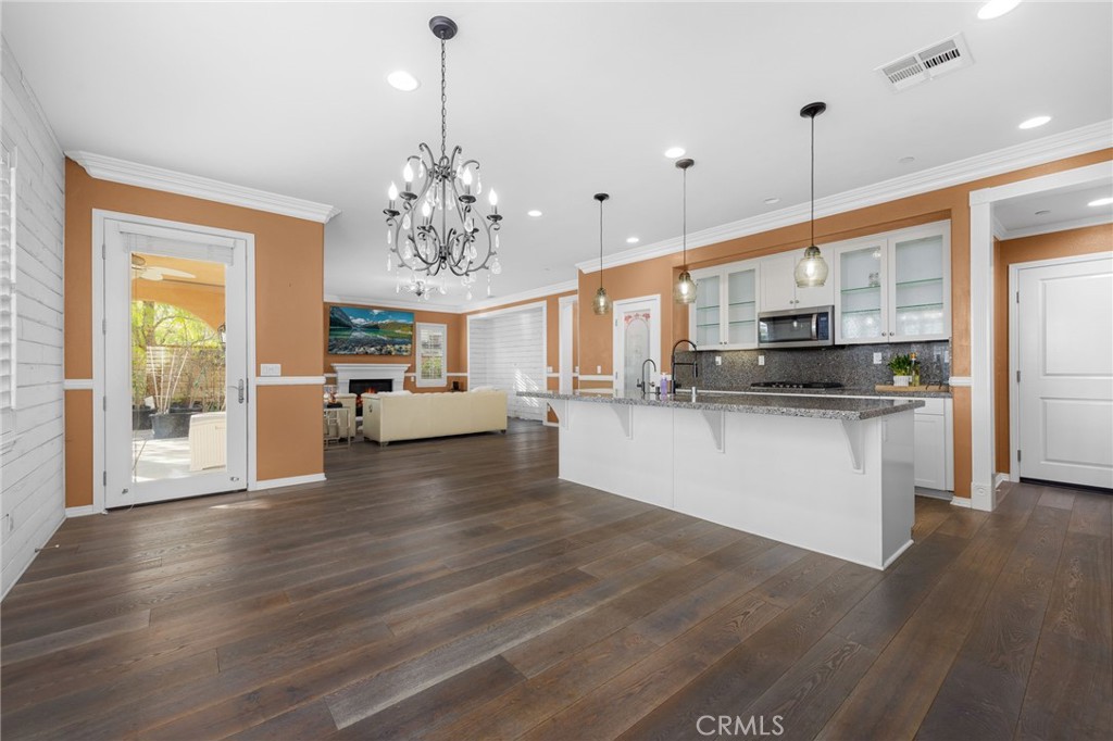 31639 Country View Road Temecula, CA 92591 - Photo 17 of 75 a kitchen with stainless steel appliances kitchen island granite countertop a stove a refrigerator a sink dishwasher and a dining table with wooden floor