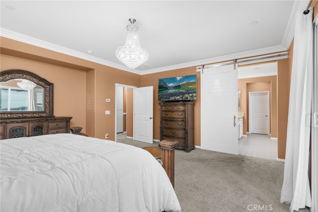 31639 Country View Road Temecula, CA 92591 - Photo 23 of 75 a bedroom with a large bed and a chandelier