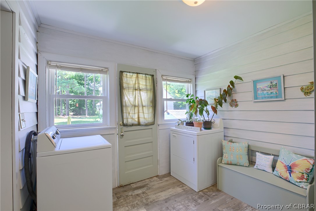 2442 Old Ferry Road Hudgins, VA 23076 - Photo 4 of 33 Laundry room with wood walls, light wood-type flooring, and independent washer and dryer