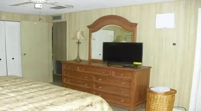 a living room with a dresser and a flat screen tv