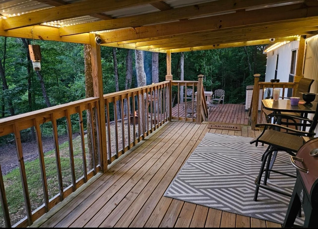 390 Wharf Road Savannah, TN 38372 - Photo 13 of 17 Spacious covered deck featuring wood flooring, natural wood railings, and a corrugated roof