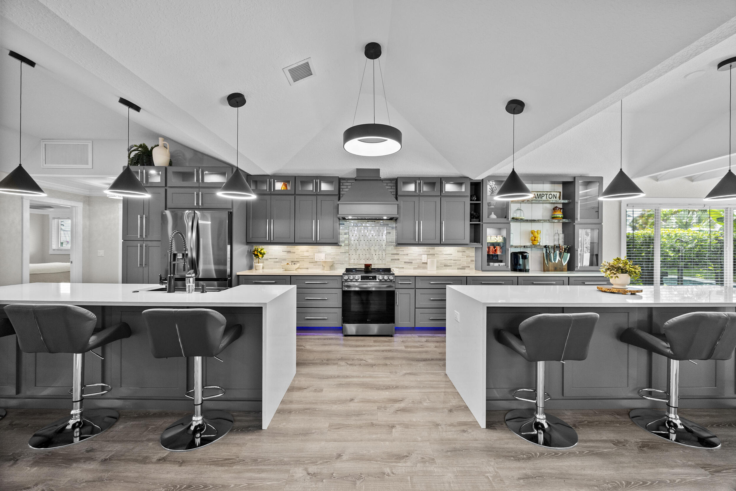 a kitchen with stainless steel appliances granite countertop a table chairs sink and cabinets