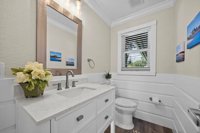 a bathroom with a granite countertop toilet sink and mirror