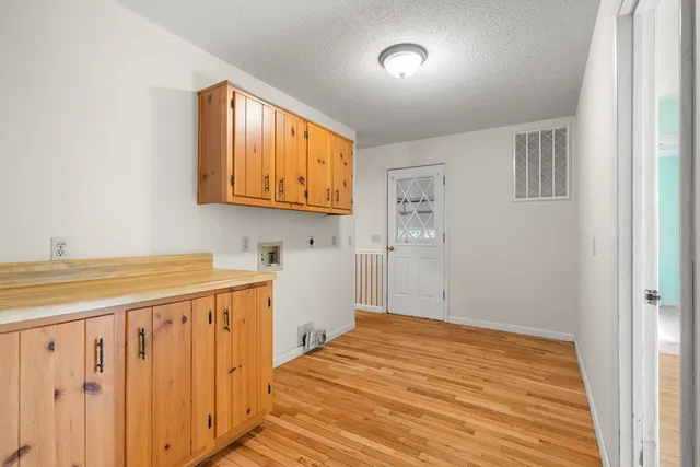 a view of a room with wooden floor and cabinet
