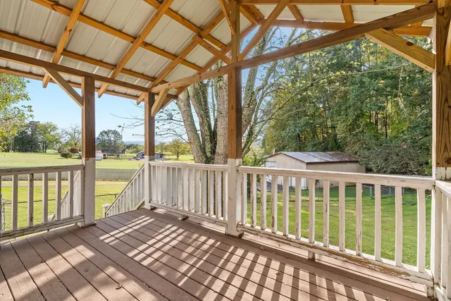 a view of a porch with wooden floor and a gate