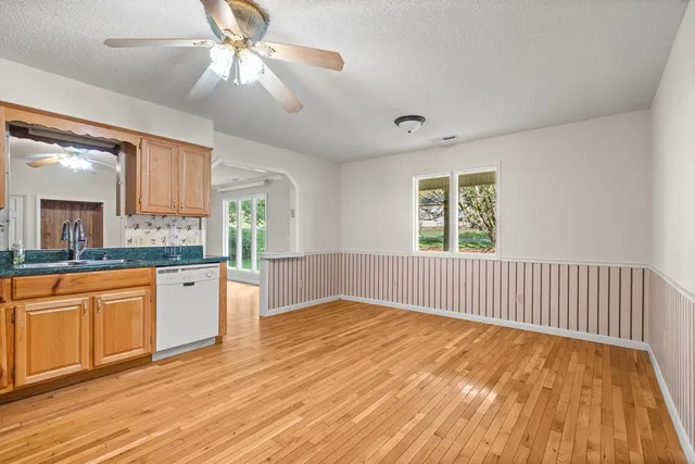a view of a kitchen with wooden floor and a ceiling fan