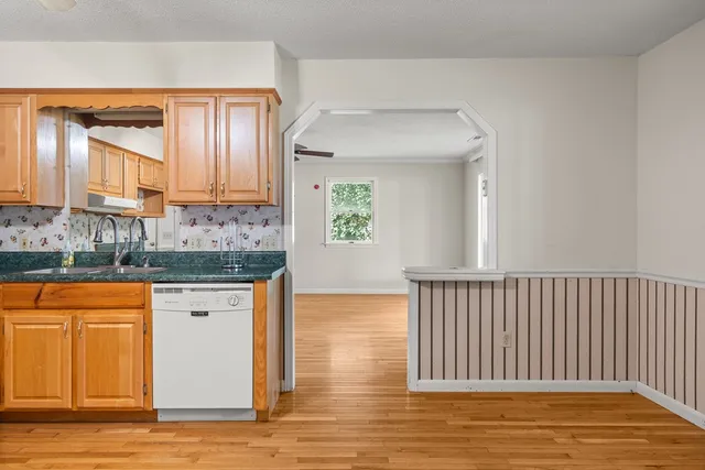a view of kitchen with granite countertop cabinets and wooden floor