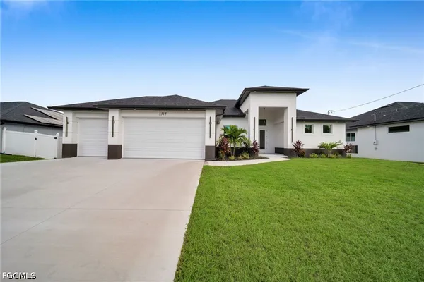 a front view of a house with a garden and plants