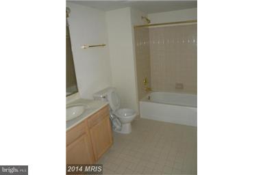 771 Bellefield Road, Unit 133 Dowell, MD 20629 - Photo 14 of 24 a bathroom with a granite countertop toilet a sink and shower
