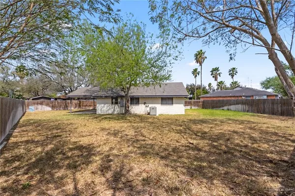 a front view of a house with a garden and tree