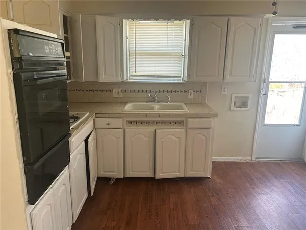 a kitchen with a sink a window and stainless steel appliances