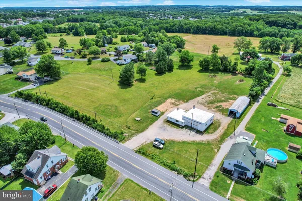 an aerial view of a house with a garden and lake view