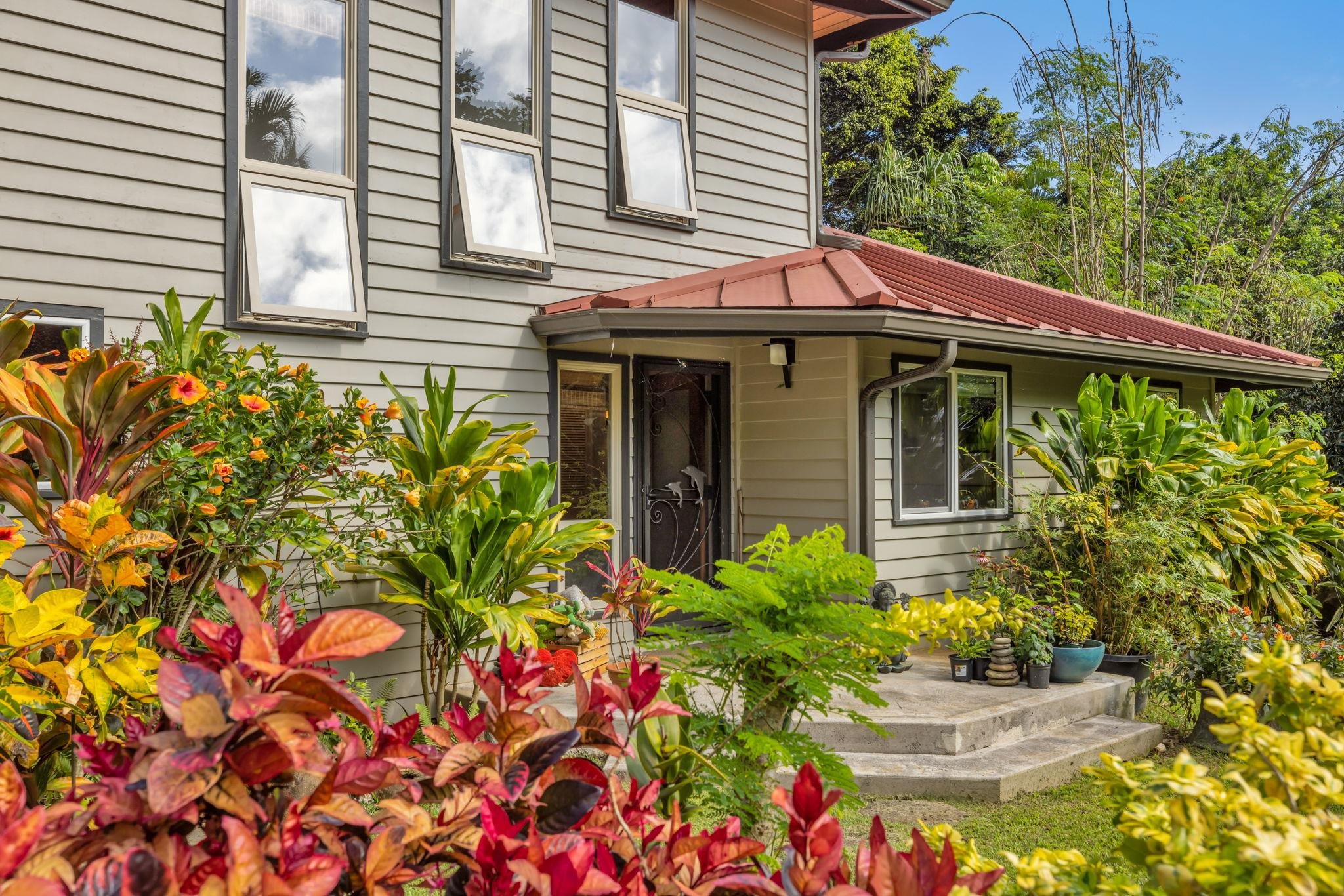 Undisclosed Address Haiku, HI 96708 - Photo 2 of 42 a front view of a house with a yard and fountain