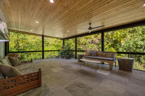 a living room with furniture and a floor to ceiling window