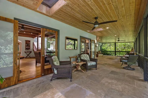 a view of a porch with chairs and a yard