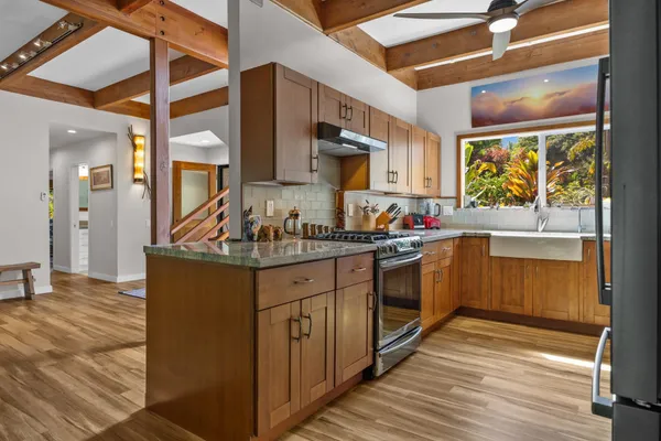 a kitchen with stainless steel appliances granite countertop a stove a sink and a refrigerator