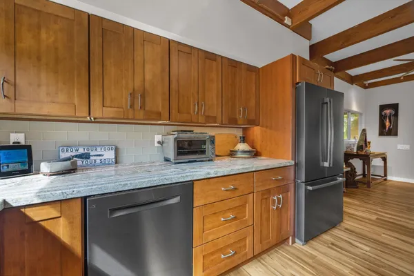 a kitchen with granite countertop wooden cabinets stainless steel appliances a sink and a counter space