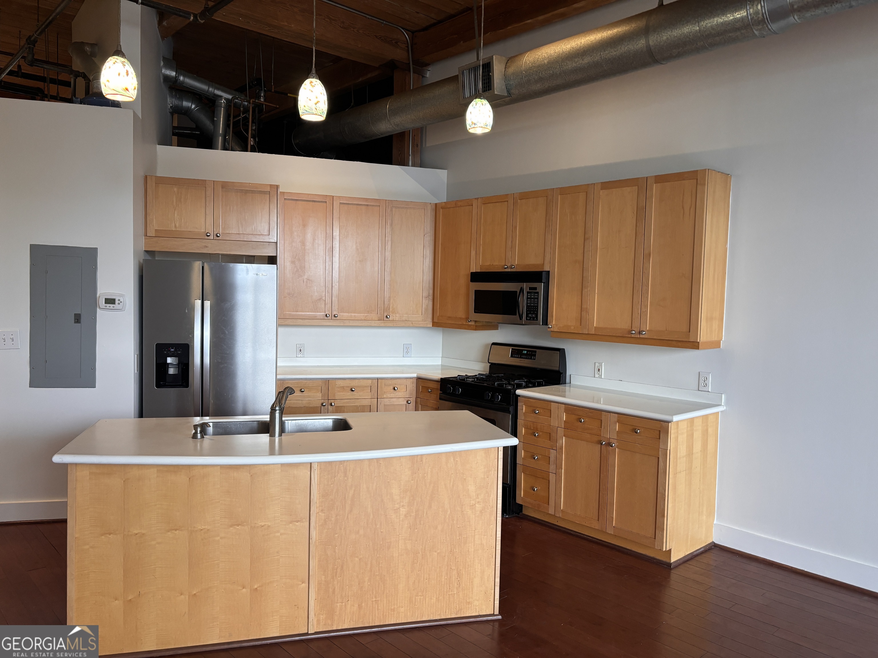 a kitchen with stainless steel appliances a stove a refrigerator a sink cabinets and wooden floor